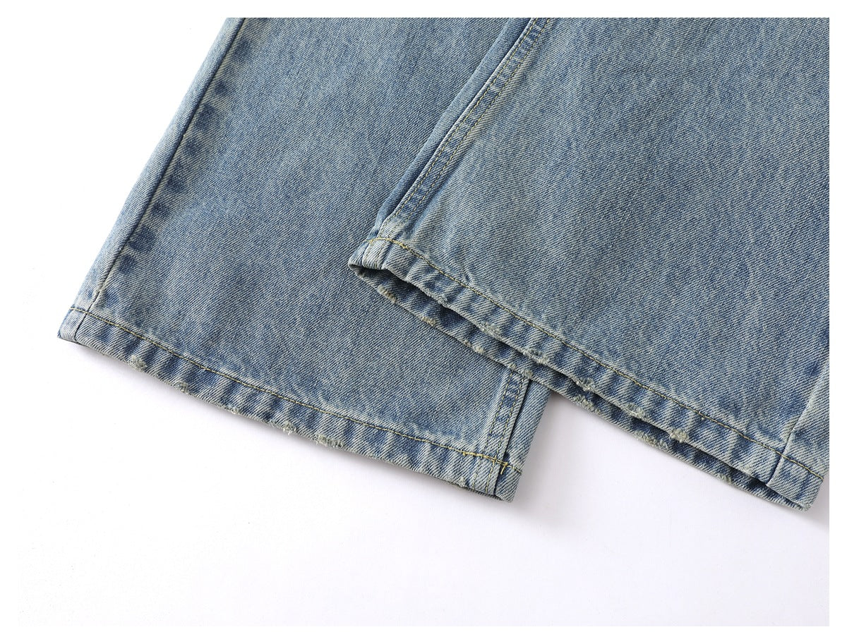 Close-up of the faded blue jeans’ leg hems and double-stitched edges.