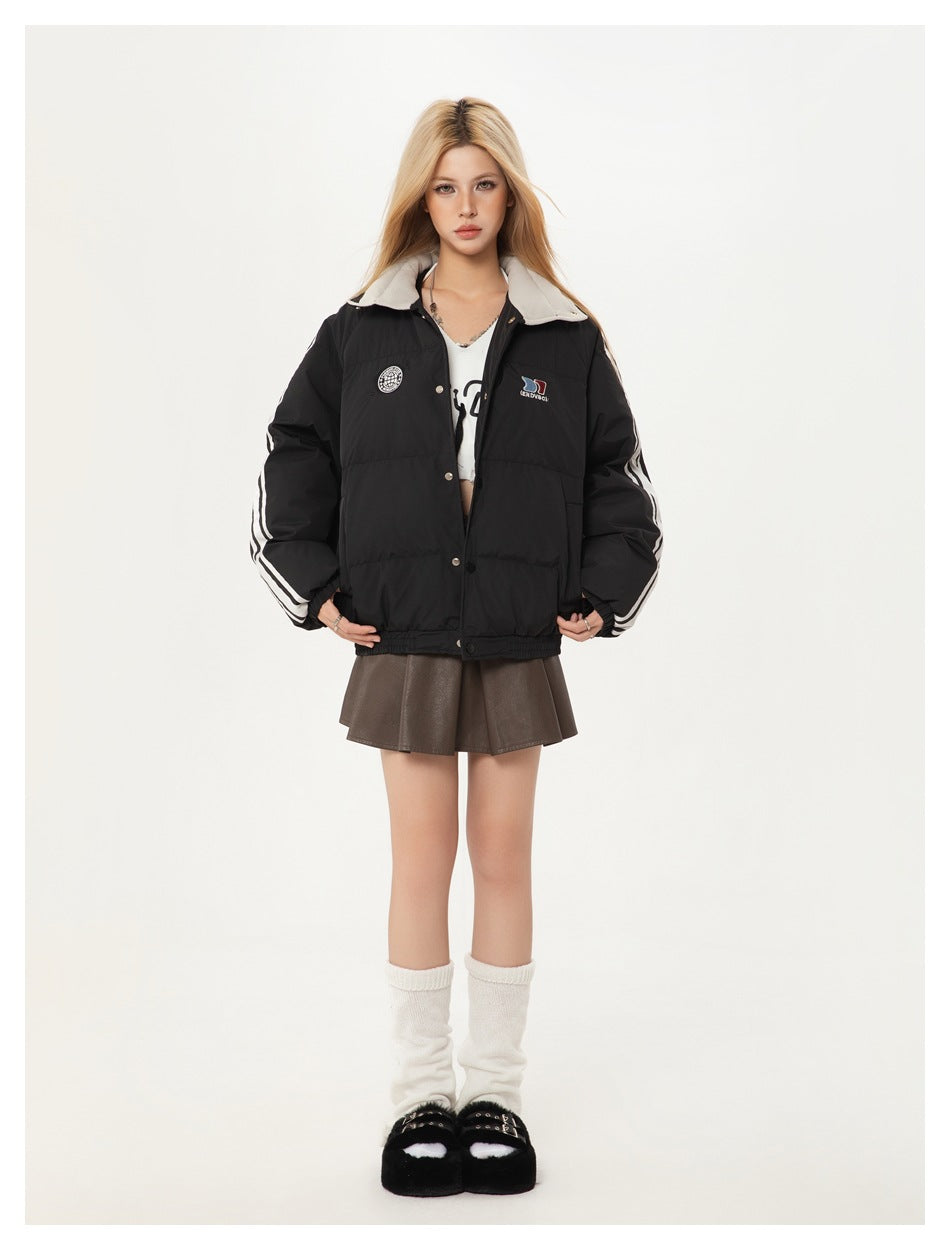 Model wearing black quilted puffer jacket with striped sleeves and light collar, styled with a brown mini skirt