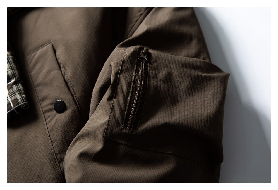 Close-up of a brown jacket sleeve with a zip pocket and snap-front panel.