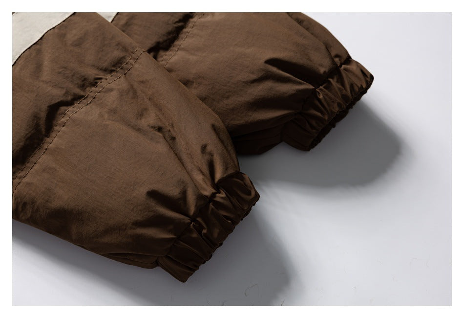 Close-up of brown garment legs with gathered elastic cuffs and a small section of cream contrast fabric.