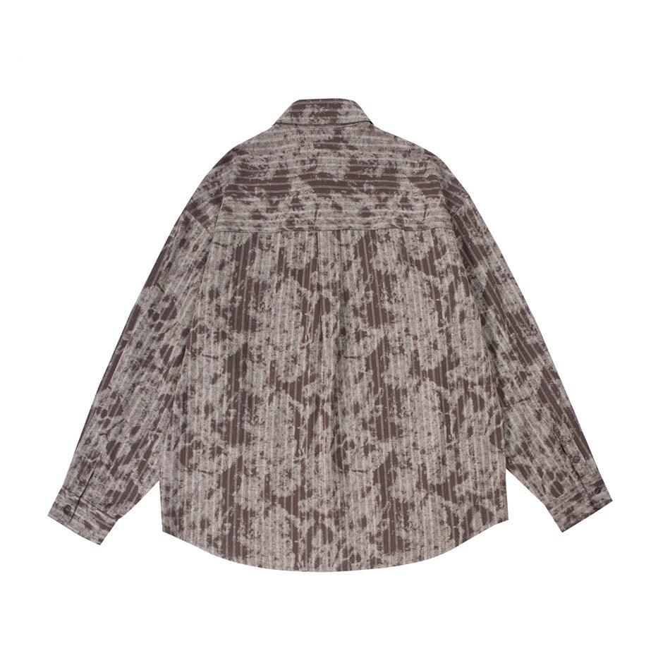 Back view of a taupe and brown shirt with distressed vertical stripes, long sleeves, and a curved hem.