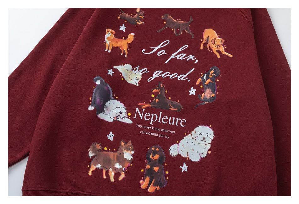Burgundy crewneck sweatshirt laid flat, with a large colorful dog illustration and English text on the front.