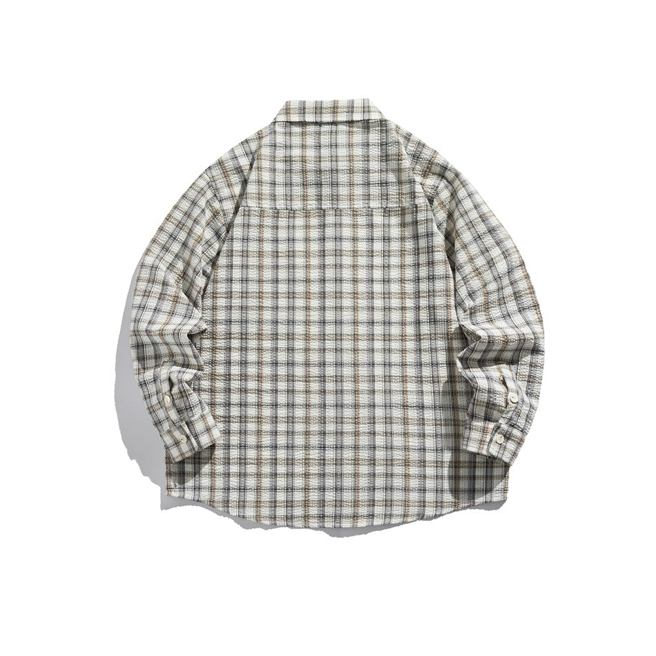 Back view of white, gray and brown plaid long-sleeve shirt showing back yoke and buttoned cuffs