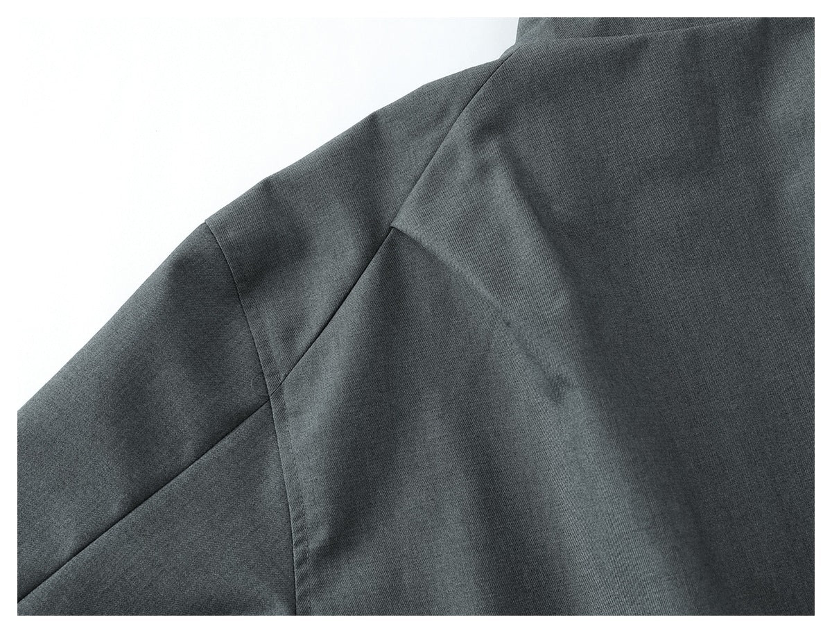 Close-up of charcoal-gray garment panels with curved and angled seams.