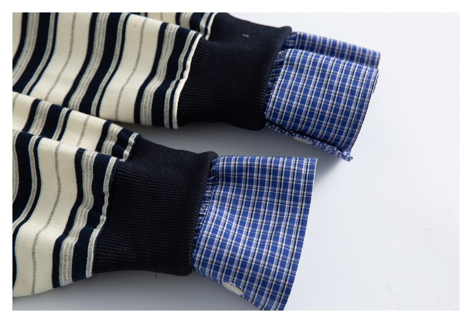 Close-up of two navy ribbed cuffs with blue plaid shirt cuffs extending beyond them.