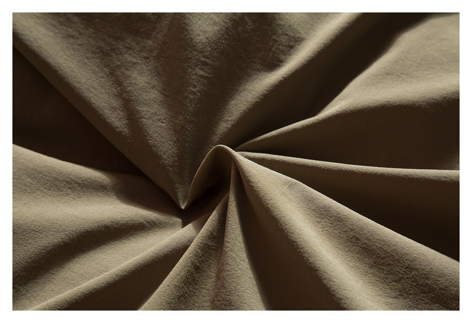 Close-up of olive-khaki fabric gathered into sculptural folds.