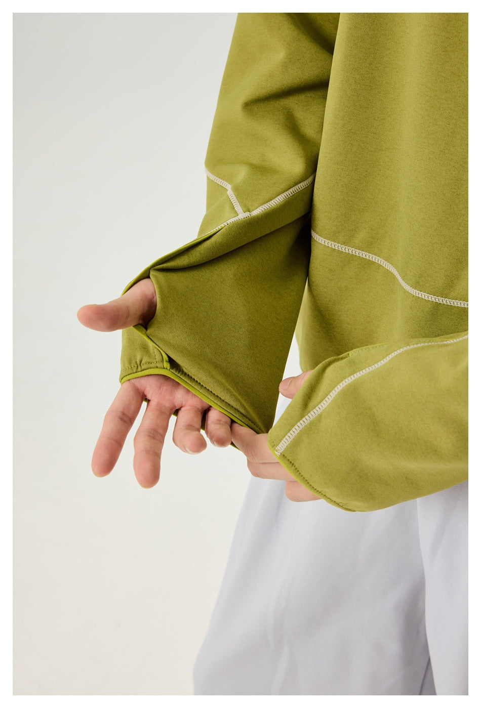Close-up of the olive-green pullover's extended cuff with a thumbhole and contrast stitching.