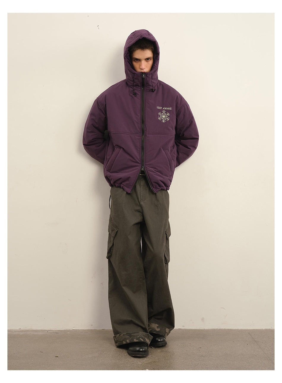 Model wearing the plum hooded zip jacket with the hood up, showing its front pockets and chest embroidery.