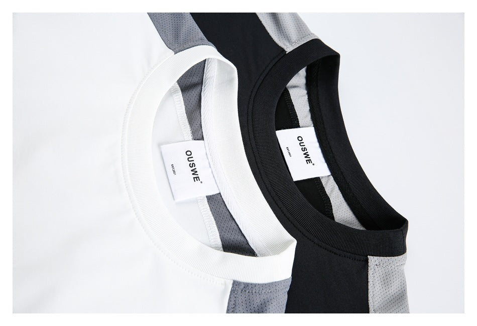 Close-up of two T-shirt necklines, one white with gray panels and one black with light-gray panels, showing labels.