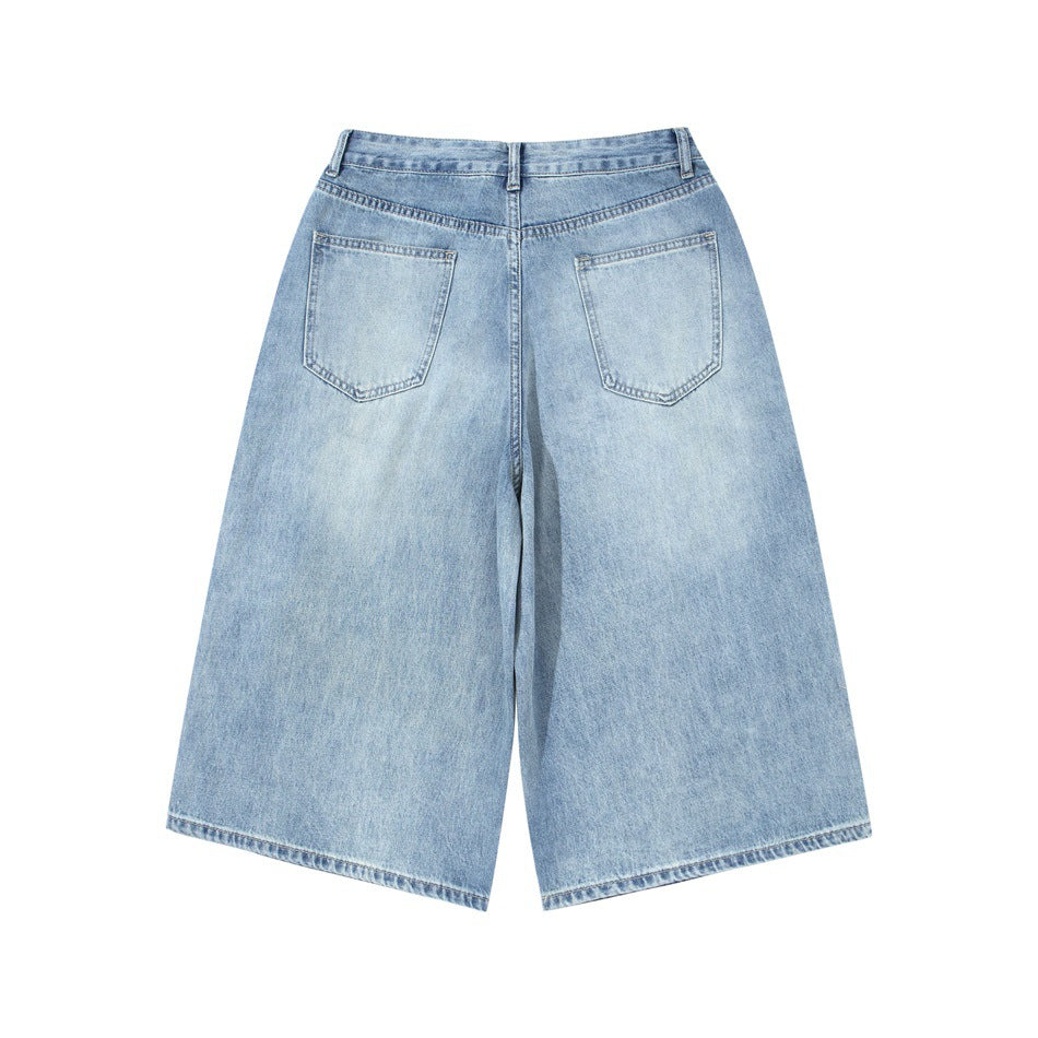 Back view of light blue wide-leg denim shorts with two patch pockets and a high waistband.