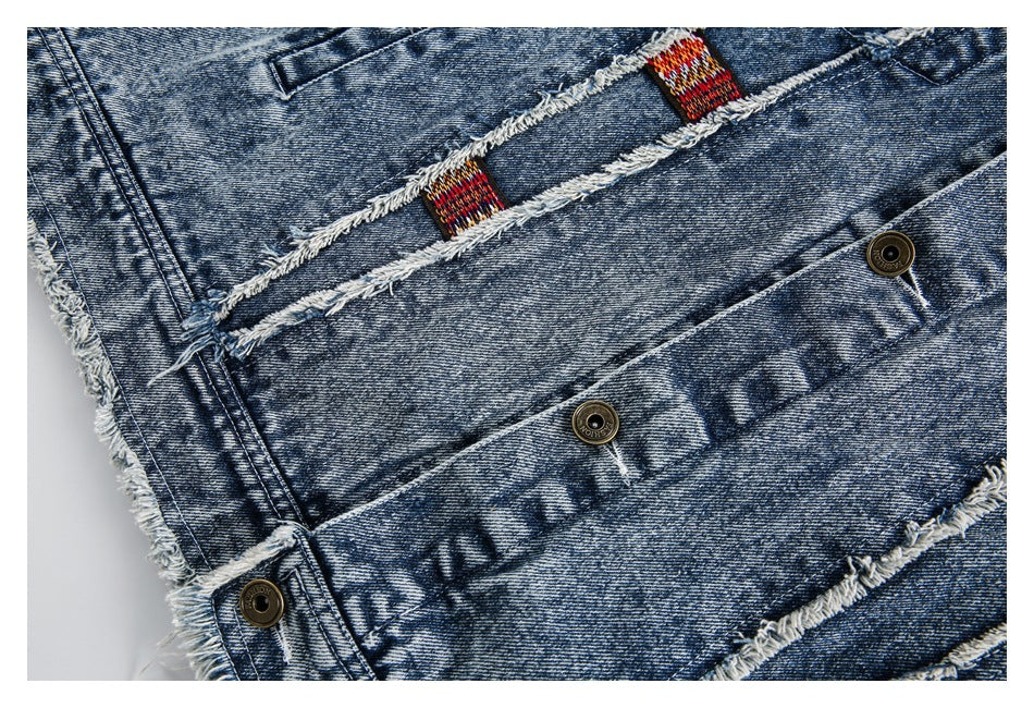 Close-up of the denim jacket's frayed seams, colorful woven tabs and metal buttons.