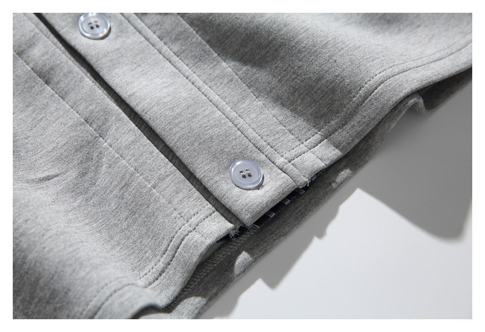 Close-up of a gray jacket button placket, stitching, and layered hem.