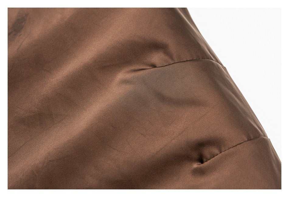 Close-up of brown garment fabric with a curved seam and stitching.