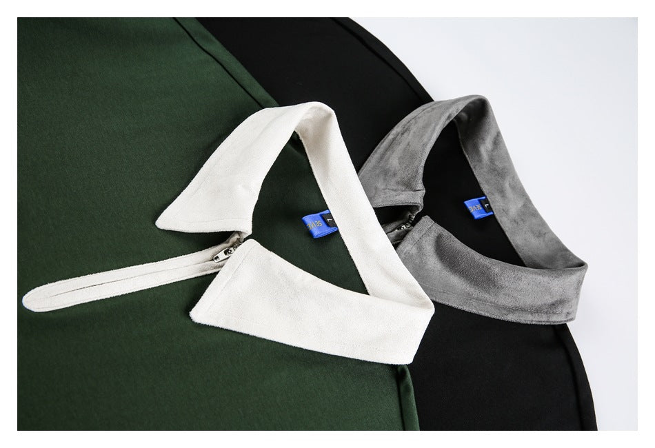 Close view of dark green and black tops with contrasting white and gray collars and short zip plackets.