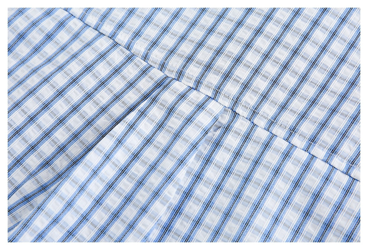 Close-up of a stitched seam joining sections of blue-and-white striped shirt fabric.