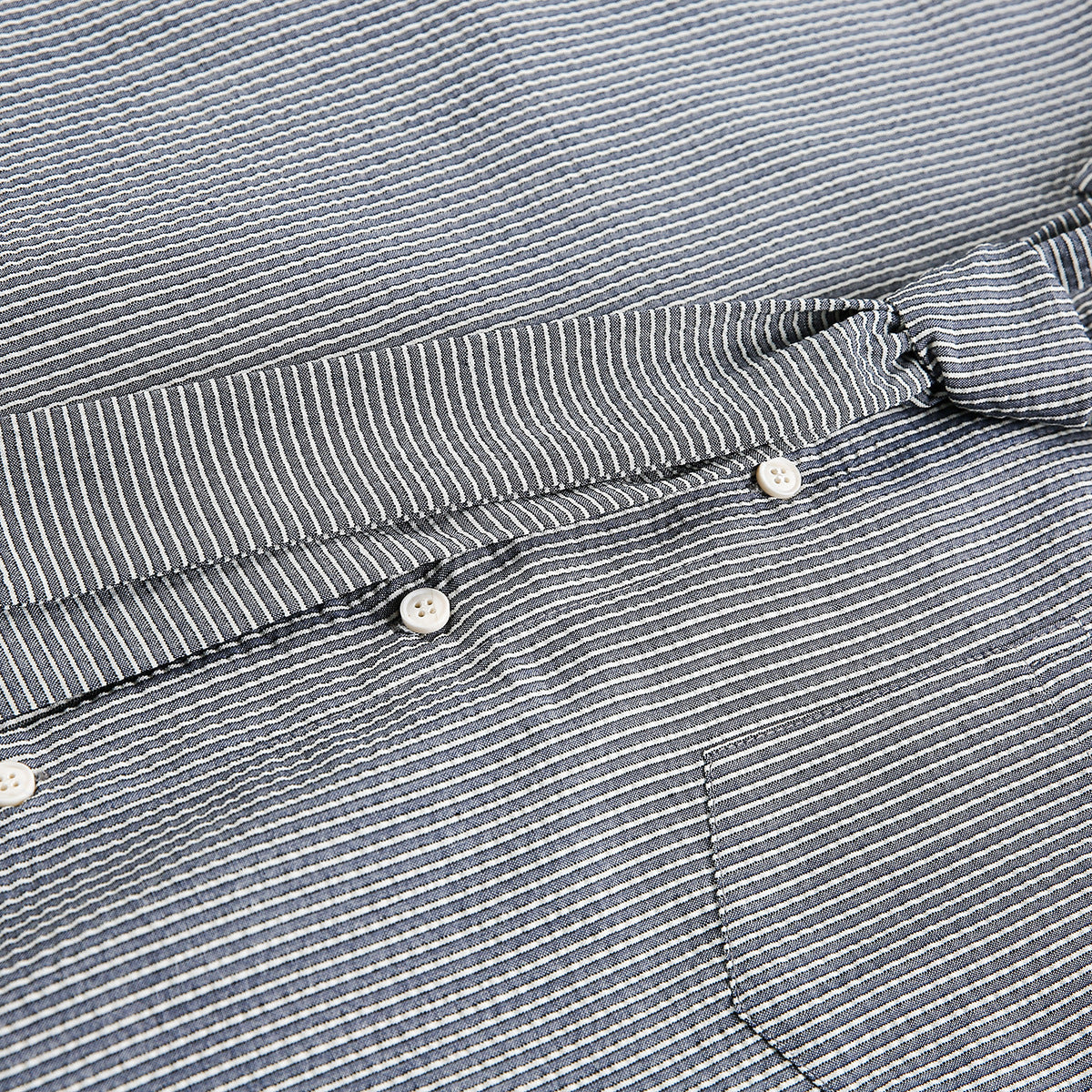 Close-up of the striped shirt's button placket and chest pocket.