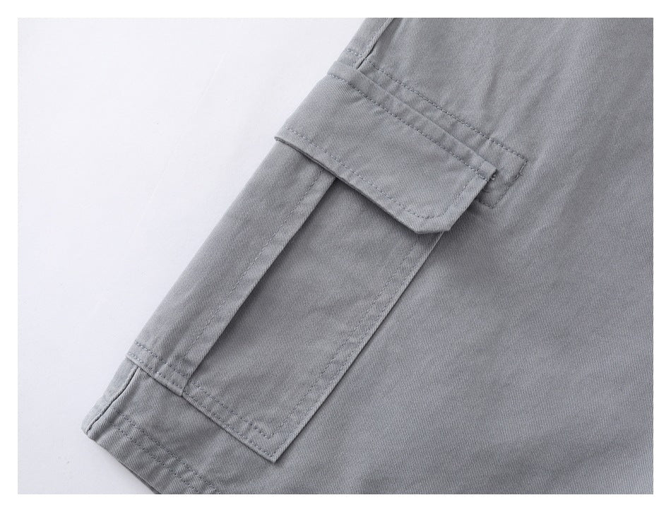 Close-up of a gray shorts cargo pocket with a flap and visible stitching.