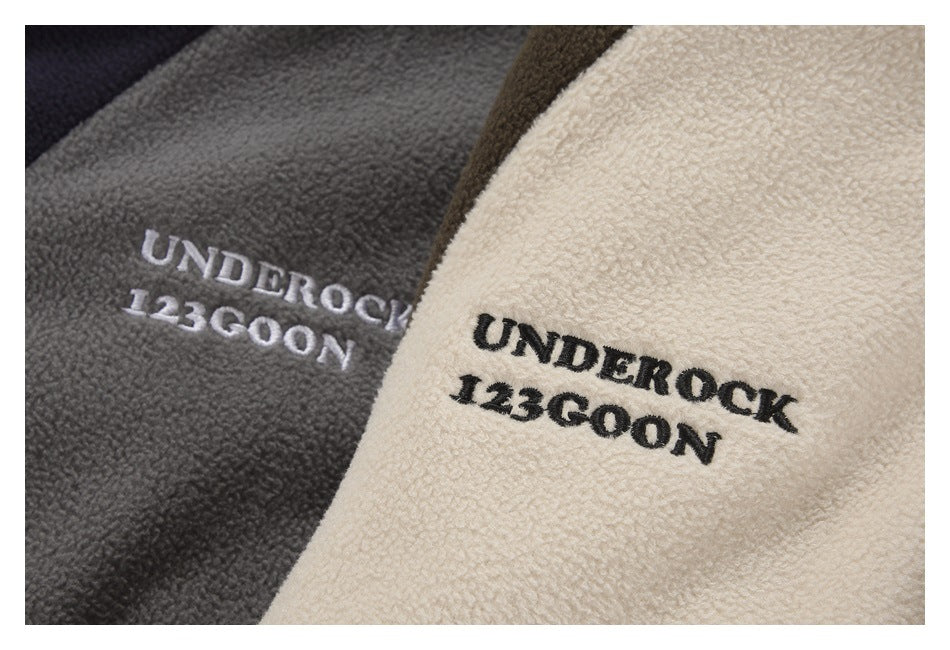 Close-up of cream and gray fabric with embroidered “UNDEROCK 123GOON” lettering.