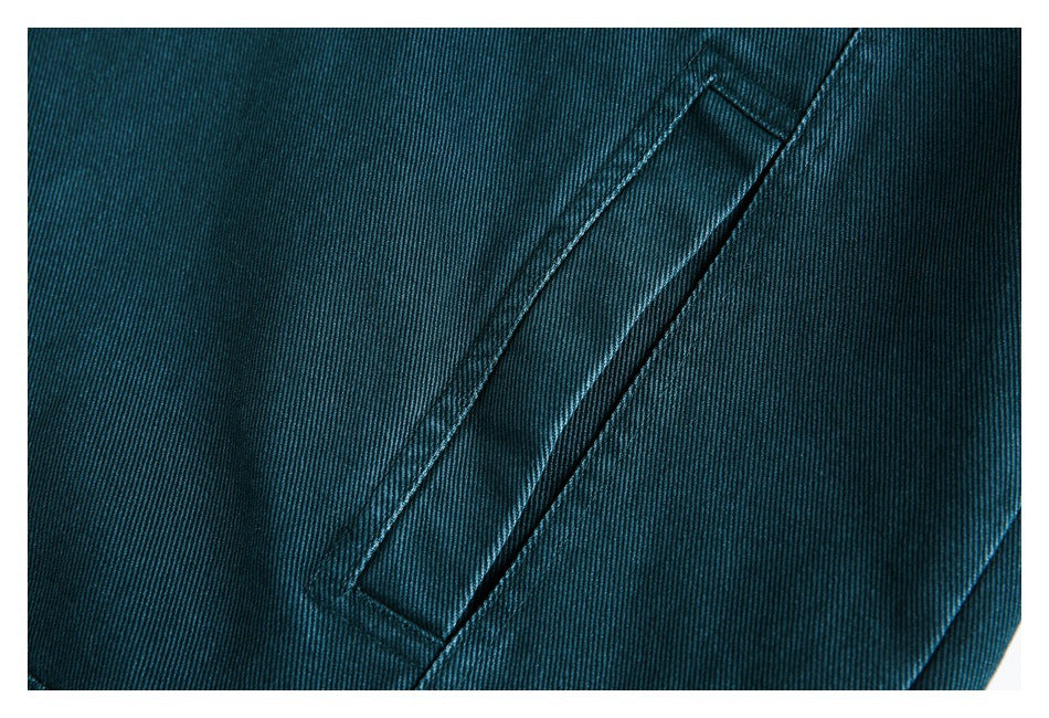 Close-up of a narrow welt pocket on teal twill fabric.