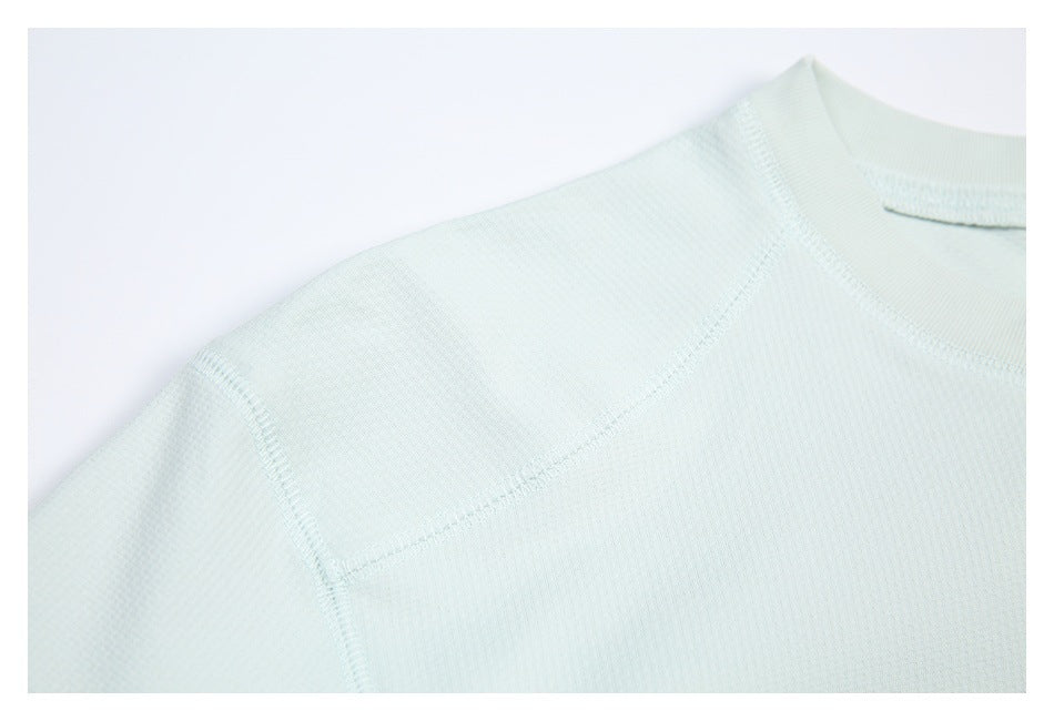 Close-up of the mint shirt's shoulder panel and visible stitching.