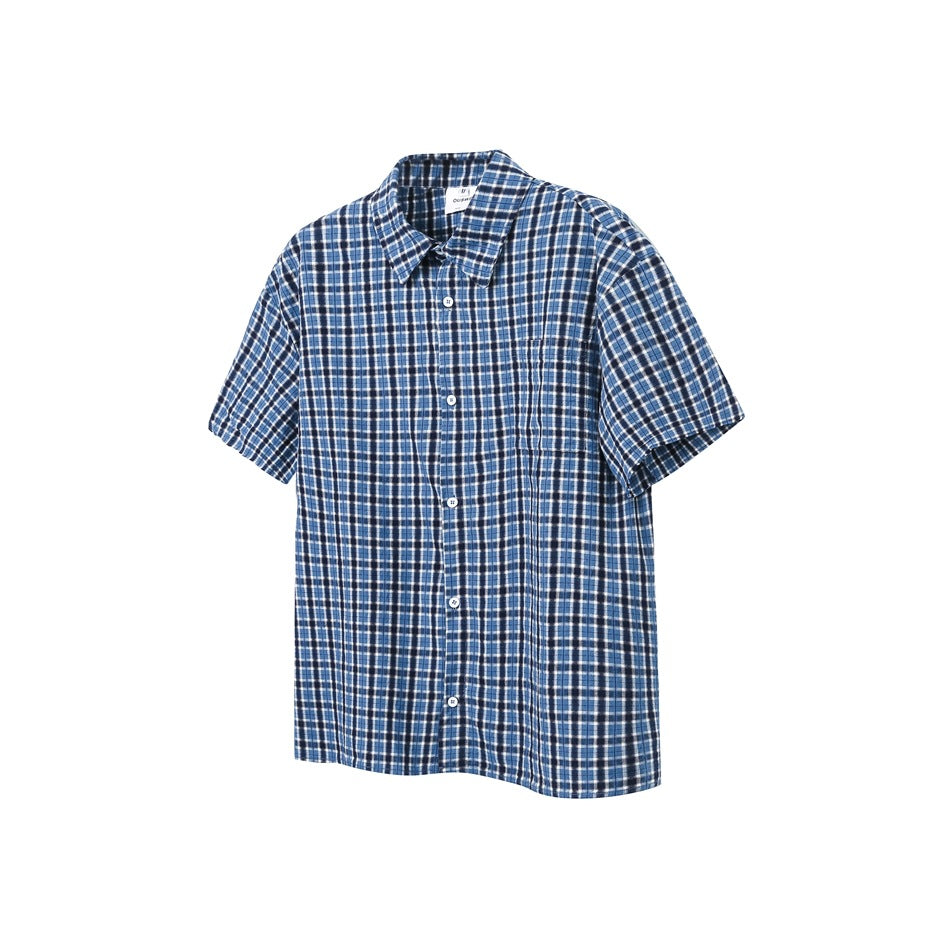 Blue, navy and white plaid short-sleeve button-up shirt with pointed collar and chest pocket, flat on white background