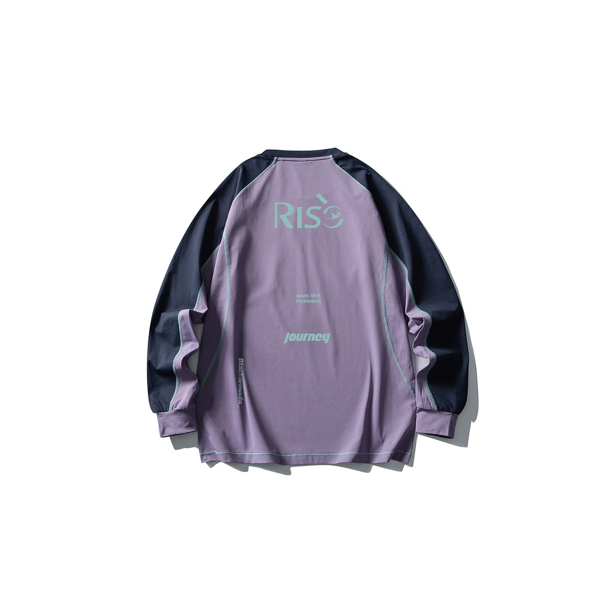 Back of a lavender shirt with dark navy sleeves, mint printed lettering, and contrast seam piping.