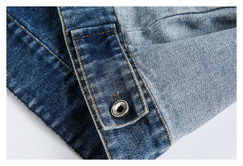 Close-up of a denim cuff tab with a metal button, dark blue panels, and contrast stitching.