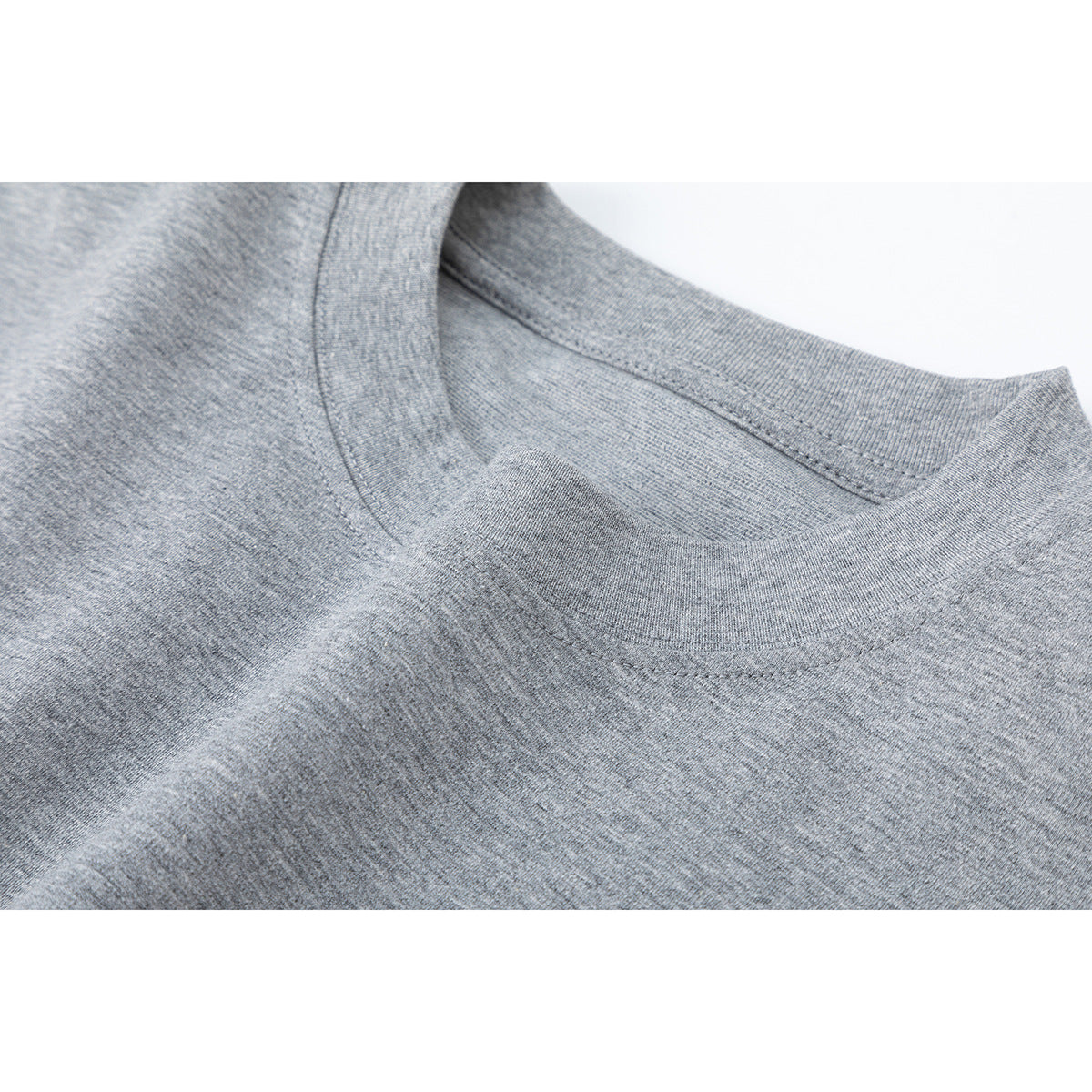 Close-up of a gray heather long-sleeve shirt's ribbed crew neckline and shoulder seam.