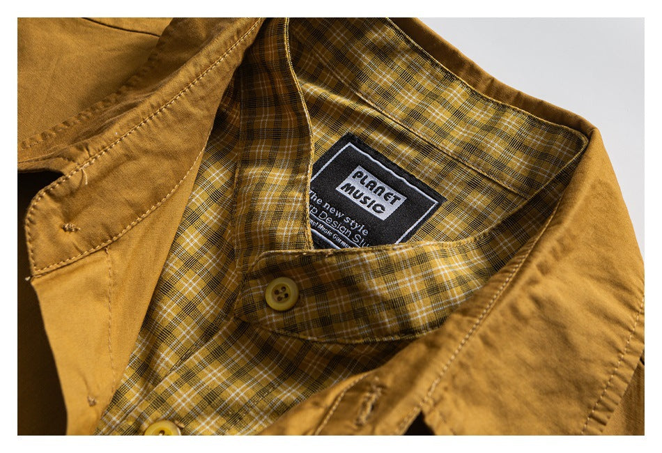 Close-up of a mustard-brown shirt collar, plaid lining, buttons, and sewn-in Planet Music label.