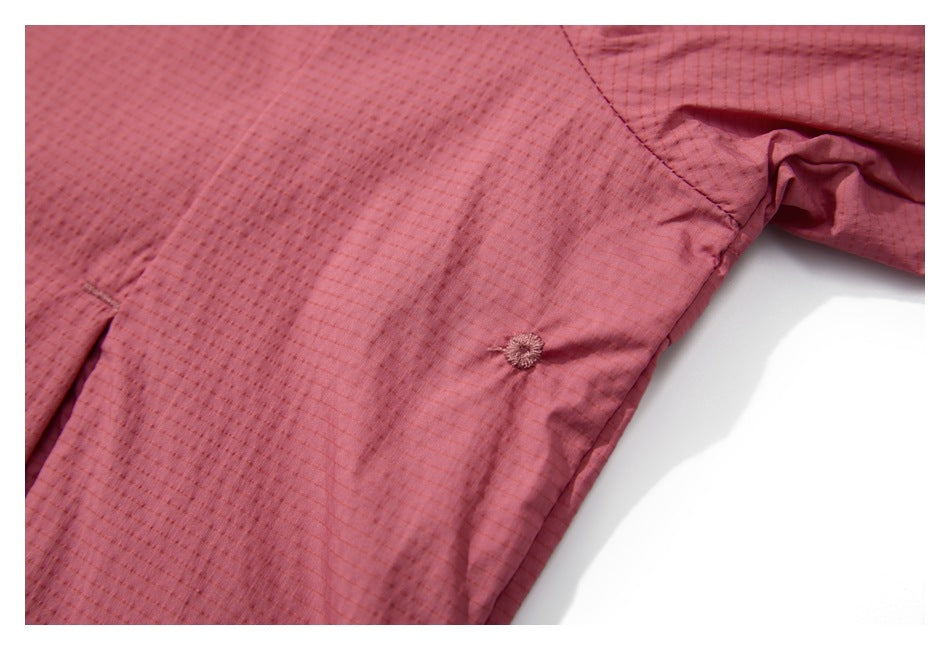 Close-up of the jacket's textured fabric, seam, and small circular stitched detail.