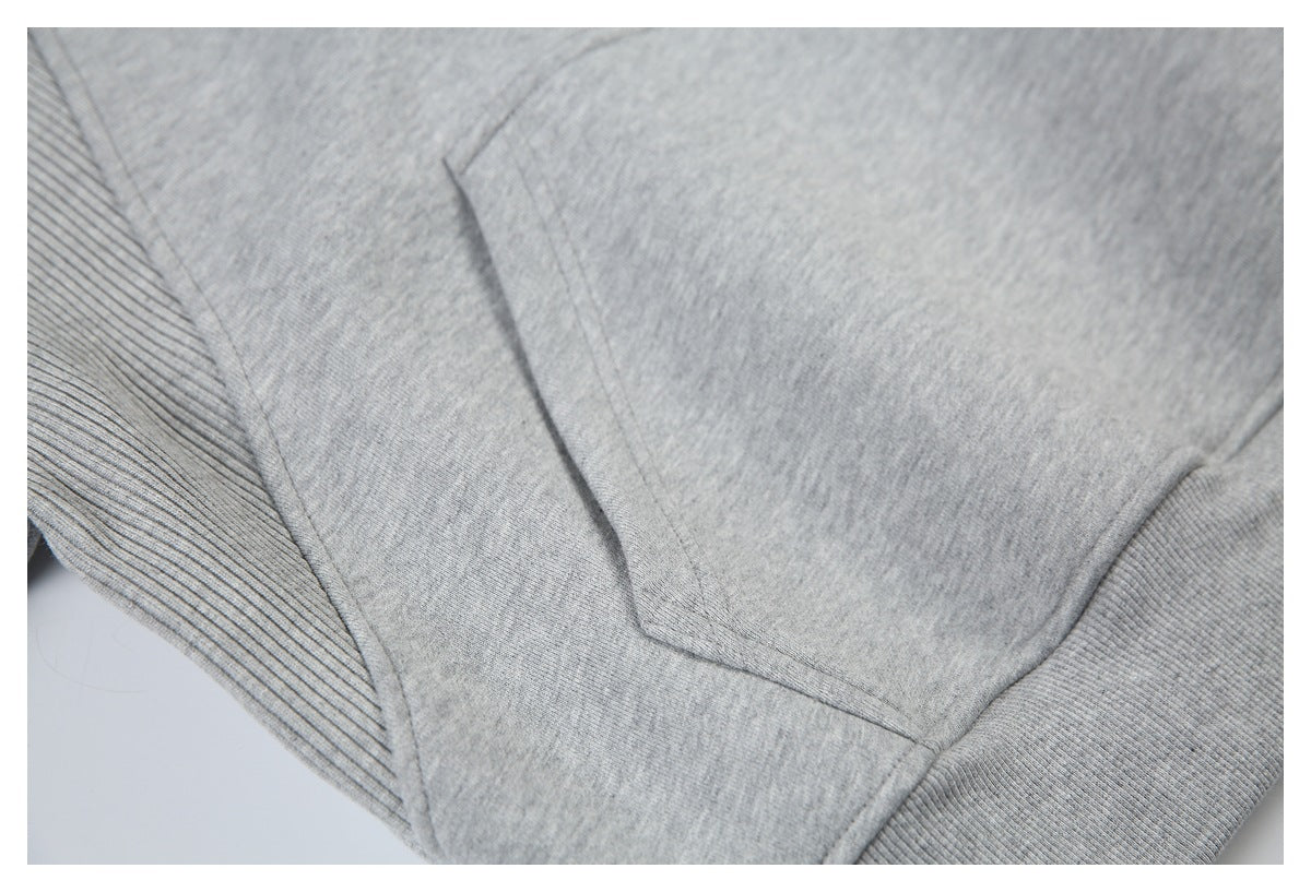 Close-up of a light gray sweatshirt showing a seam and ribbed edge.