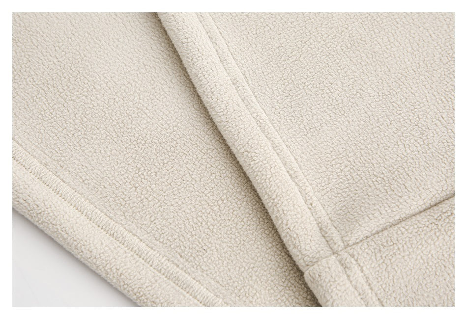 Close-up of cream textured fabric with a bound edge and visible seam stitching.