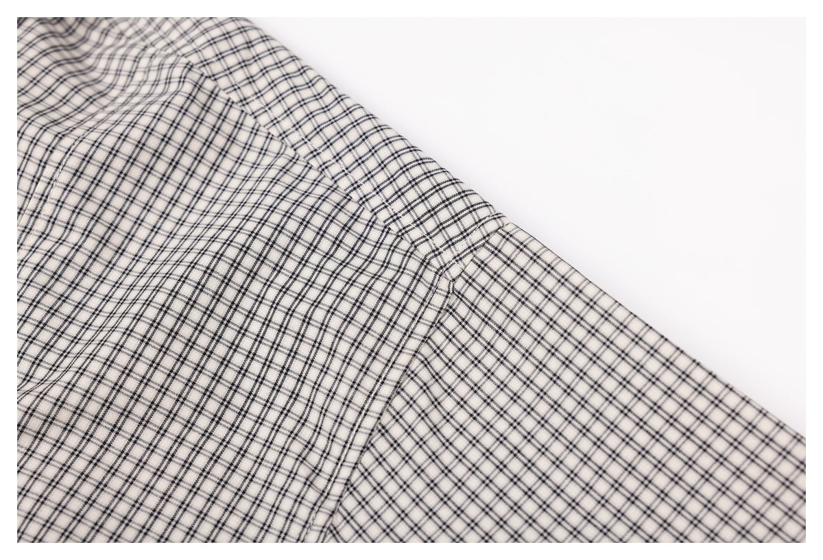 Close-up of the checked shirt fabric and a diagonal stitched seam.