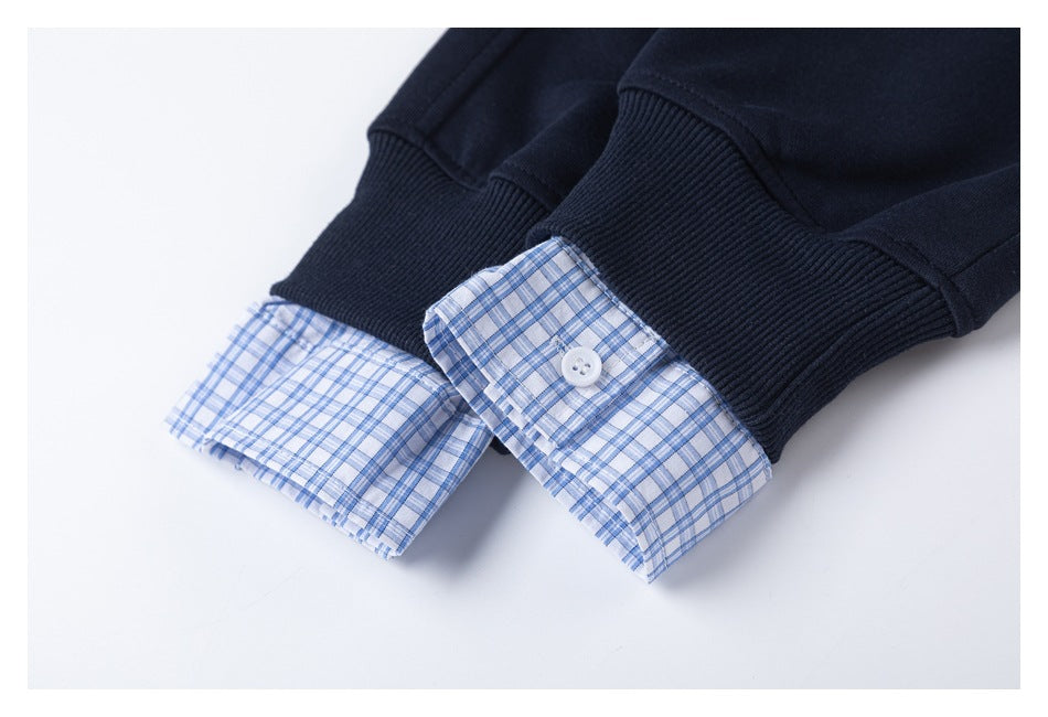 Navy ribbed sweatshirt cuffs with blue-and-white plaid shirt cuffs showing beneath.