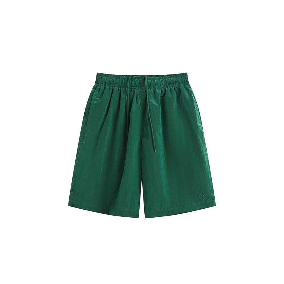 Green knee-length drawstring shorts with elastic waistband, flat front view on white background