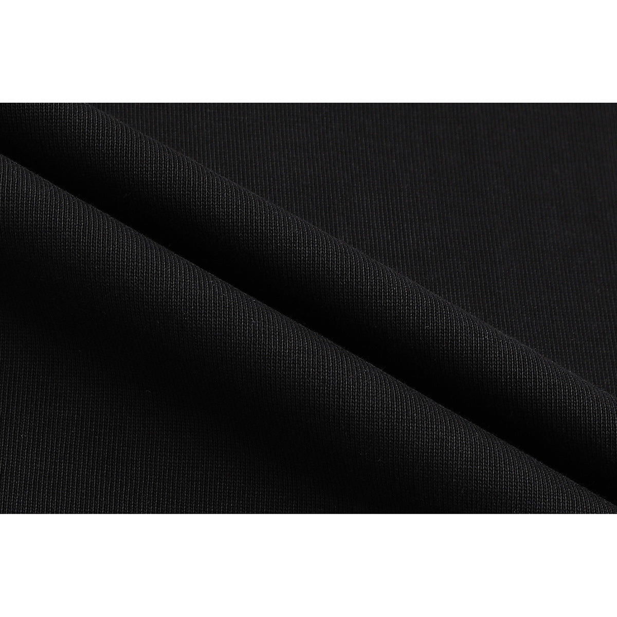 Macro view of black fabric folded to show its fine knit texture.