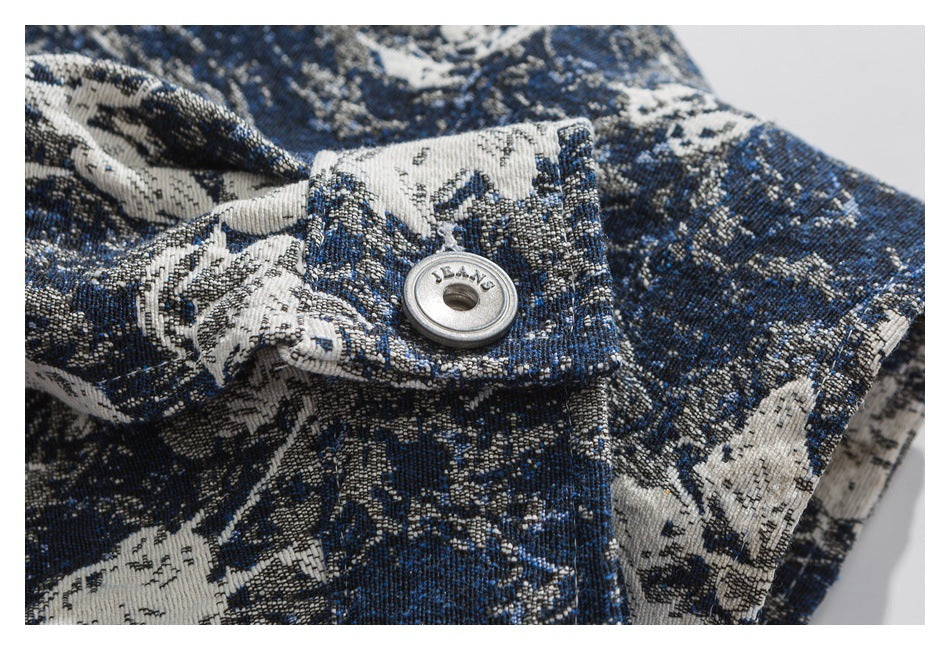 Close-up of a metal button on a blue and ivory floral-patterned garment.