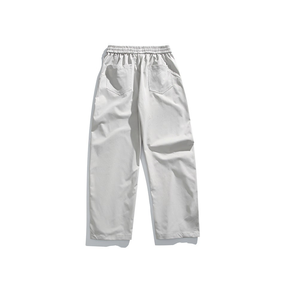 Back view of light gray trousers with an elastic waistband and two rear patch pockets.