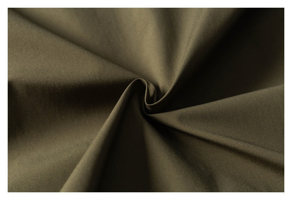 Close-up of olive-brown fabric gathered into a central twist, showing its fine woven texture.