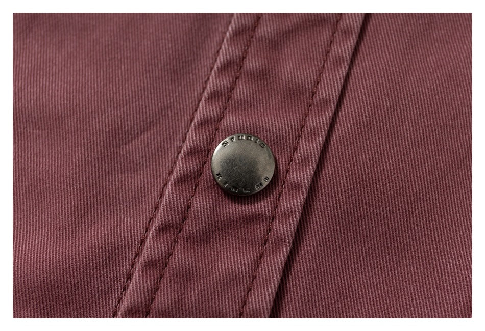 Close-up of a metal snap button and stitched placket on the dusty mauve overshirt.