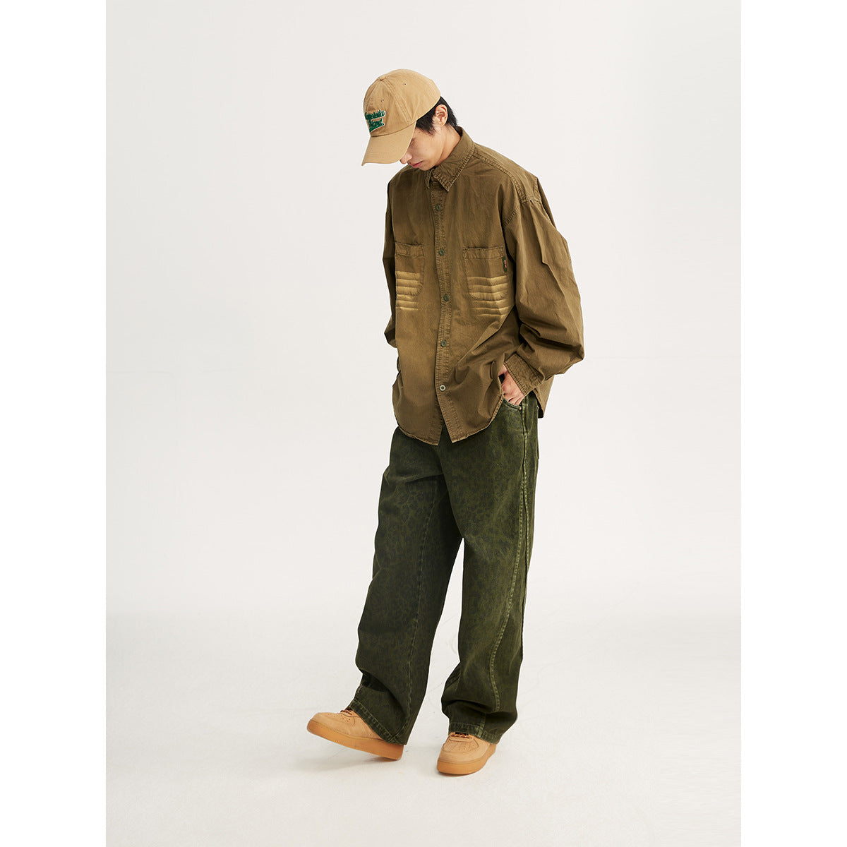 Model wearing an olive-brown button-front shirt with faded horizontal bands across two chest pockets.