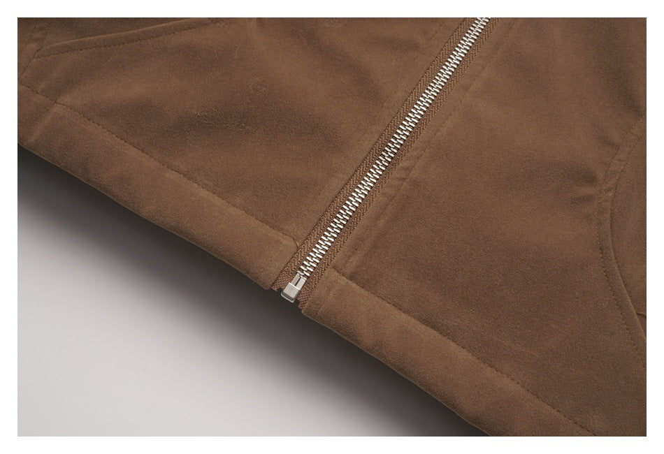 Close-up of a brown jacket’s lower edge and diagonal silver zipper.