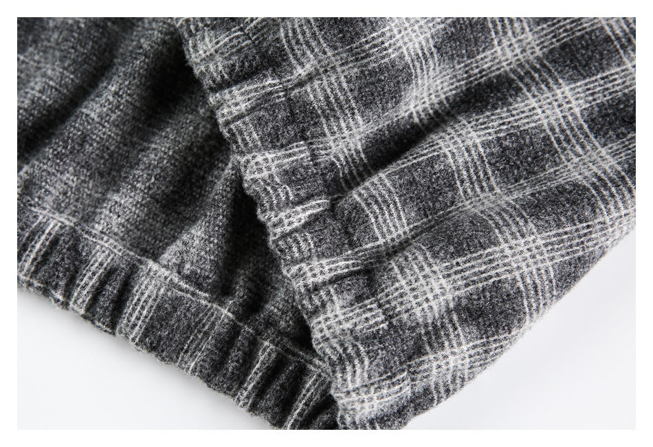 Close-up showing overlapping seams and folded edges in charcoal gray plaid fabric.