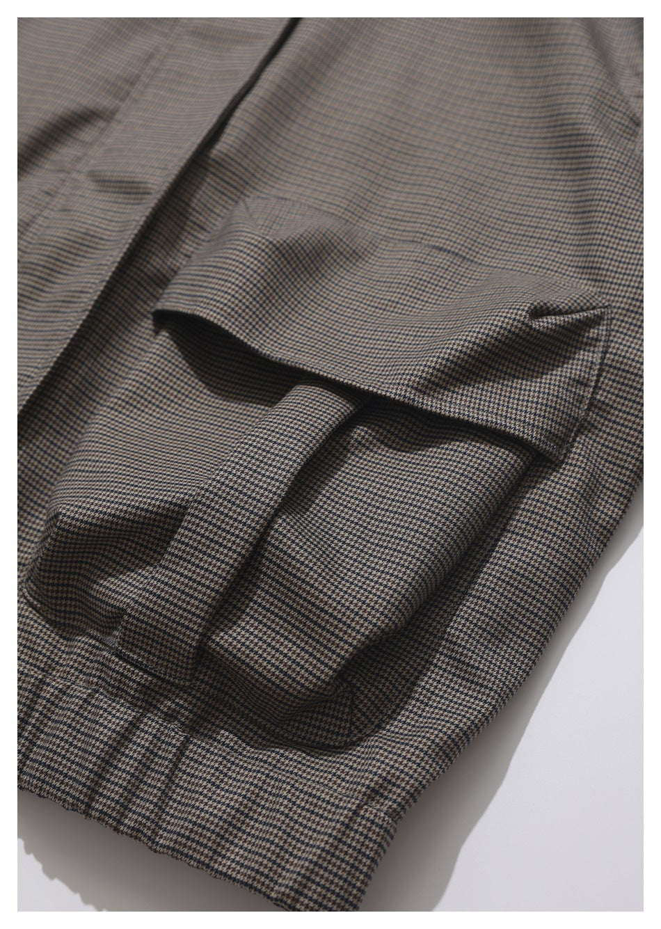 Close-up of a houndstooth jacket's flap pocket and matching cuff.