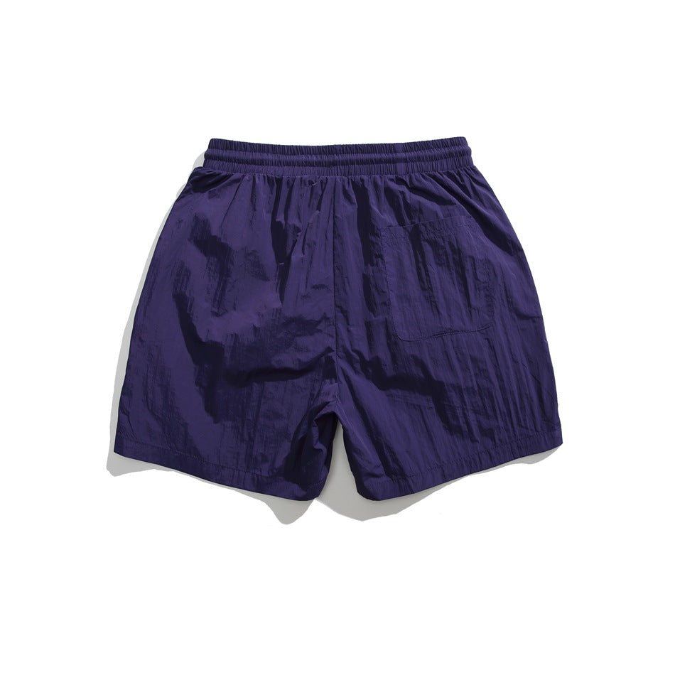Back view of deep purple shorts with an elastic waistband and a single rear patch pocket.