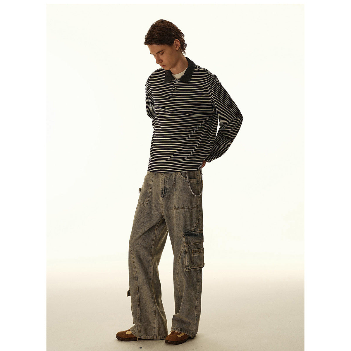 Model wearing a black-and-cream striped long-sleeve polo with loose gray cargo jeans.