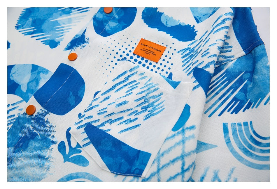 Close-up of the blue-and-white printed shirt, showing its pocket, orange buttons, and sewn orange label.