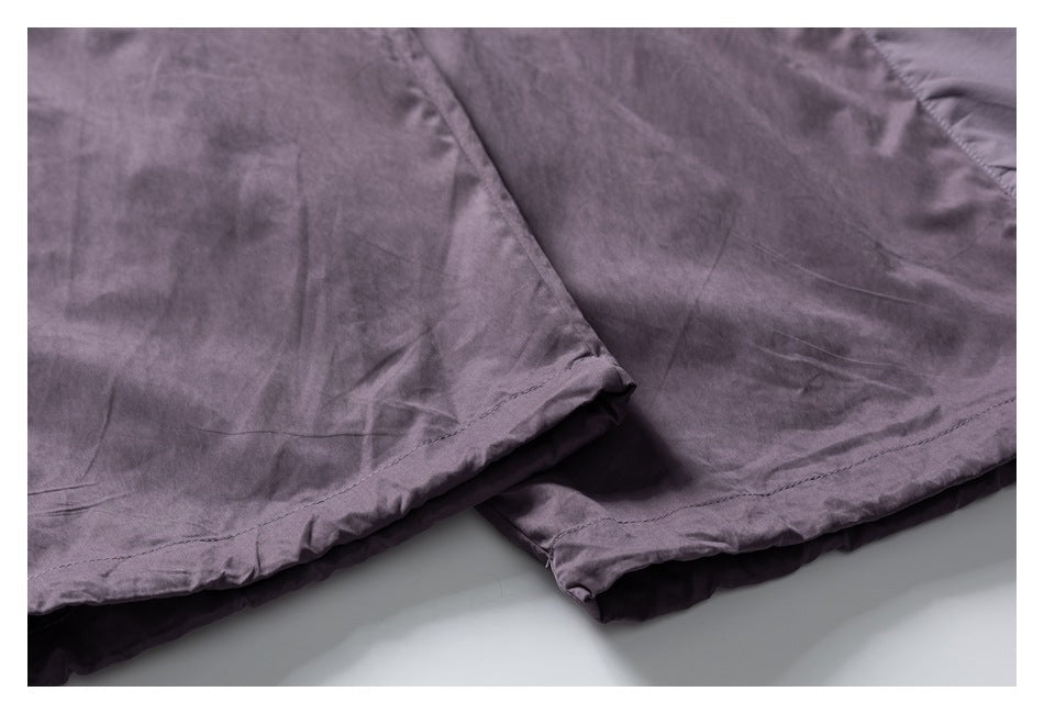 Close-up of the mauve-gray pants' stitched leg hems.