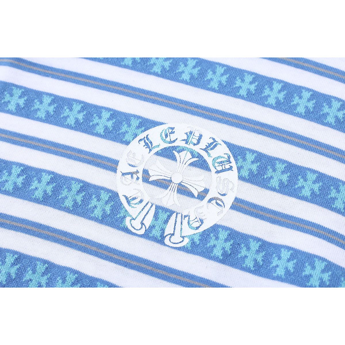 Close-up of a circular white emblem on blue, white, and gray striped fabric.