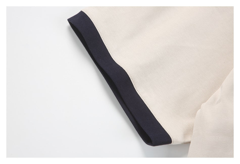 Close-up of an off-white sleeve edge finished with a dark band.